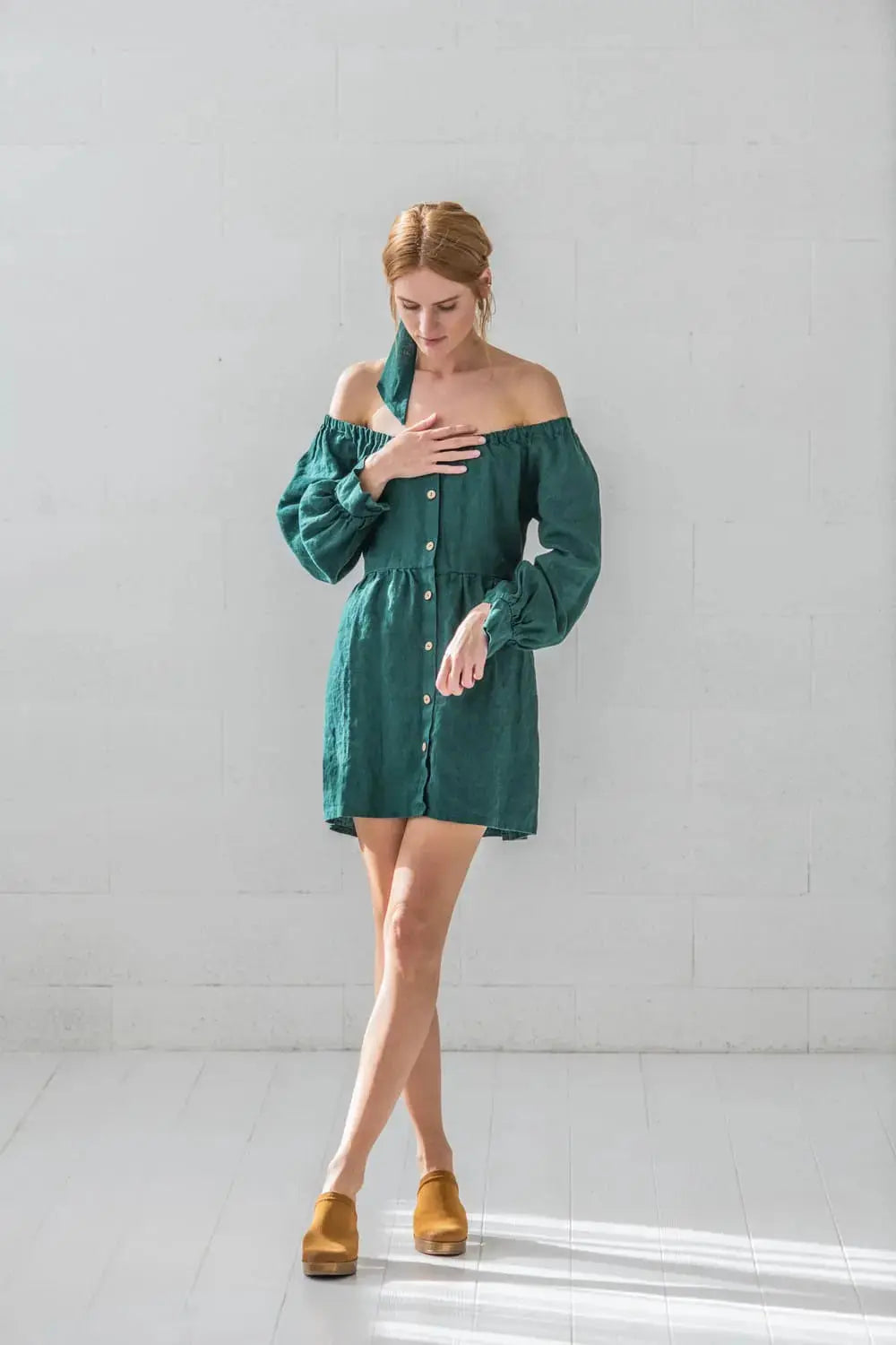 Close-up of linen off-shoulder balloon sleeve mini dress with natural coconut button detail