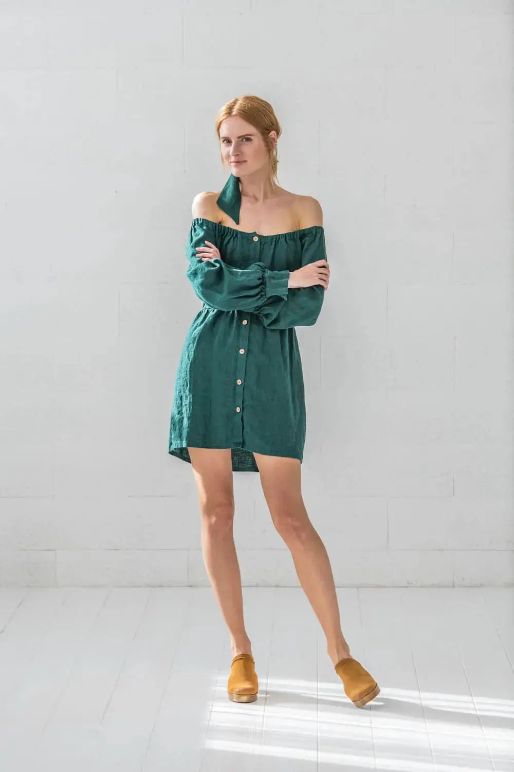 Woman wearing linen balloon sleeve off-shoulder mini dress with coconut buttons