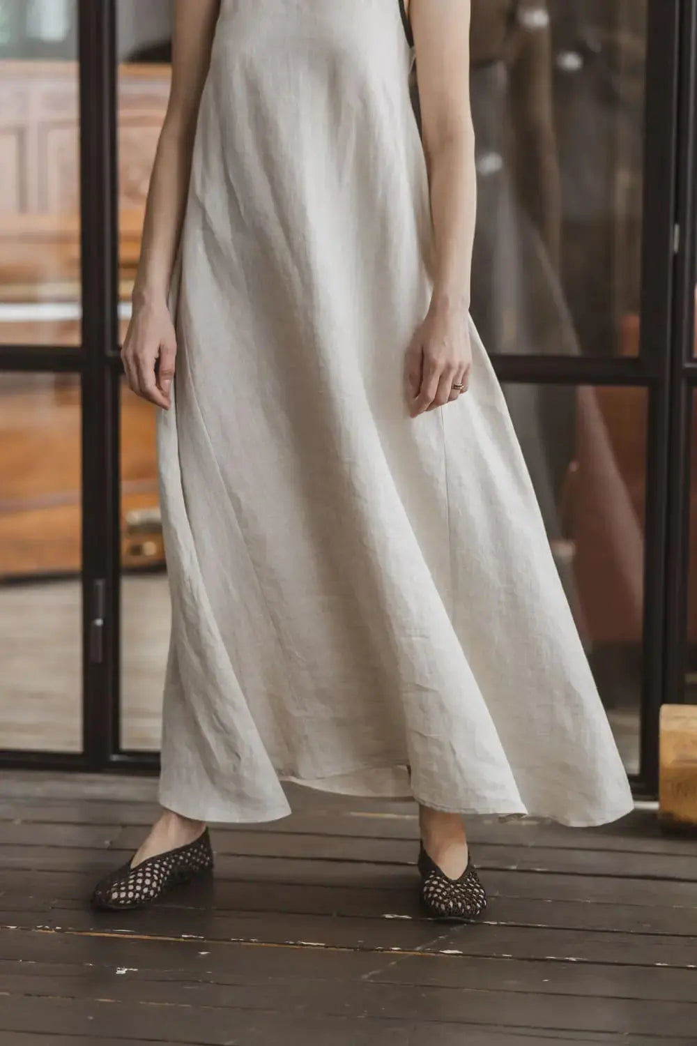 Front view of a natural linen maxi slip dress with A-line silhouette, waist down