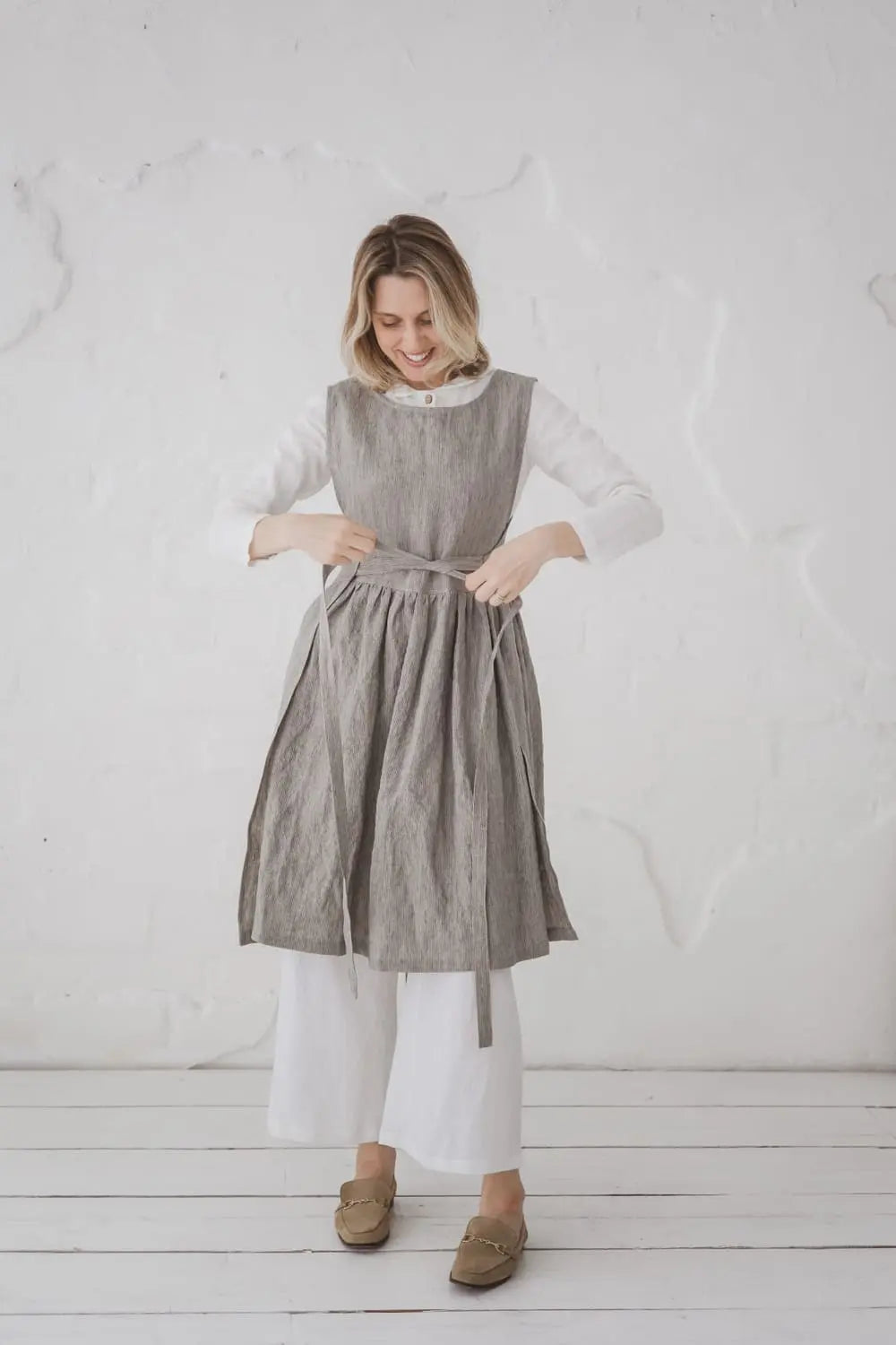 Woman tying Convertible Linen Pinafore Dress at front - Epic Linen