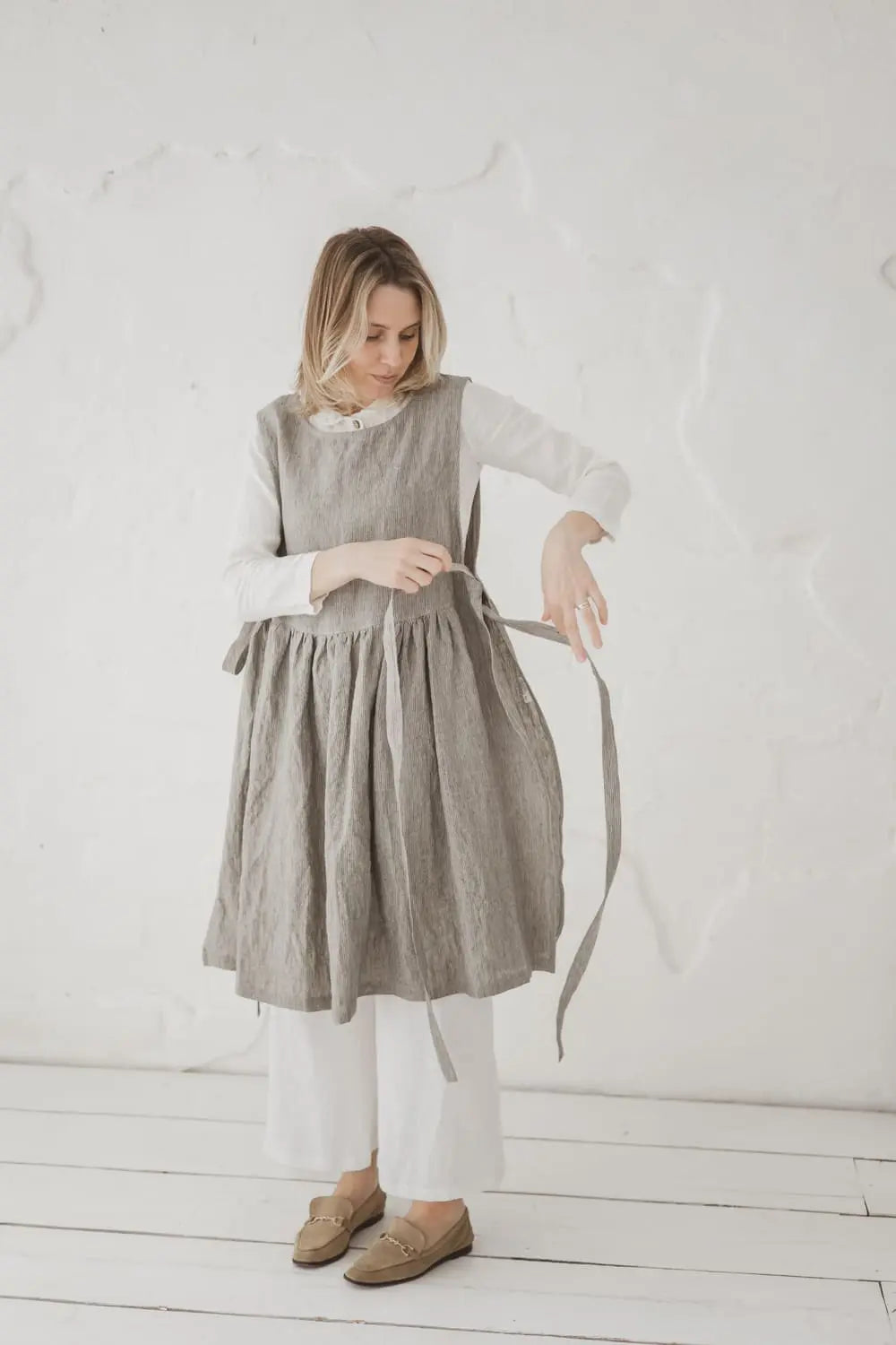 Woman tying front straps of Convertible Linen Pinafore Dress - Epic Linen