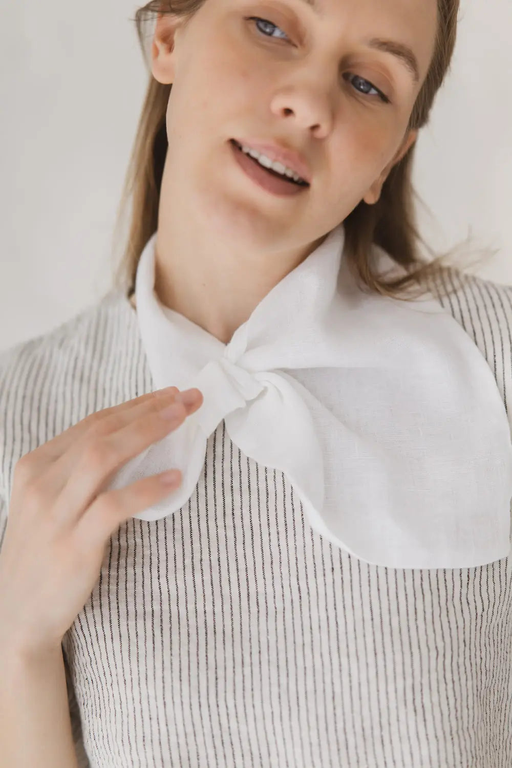 Close-up of light white gauze linen neckerchief showing soft texture and pre-stitched loop detail