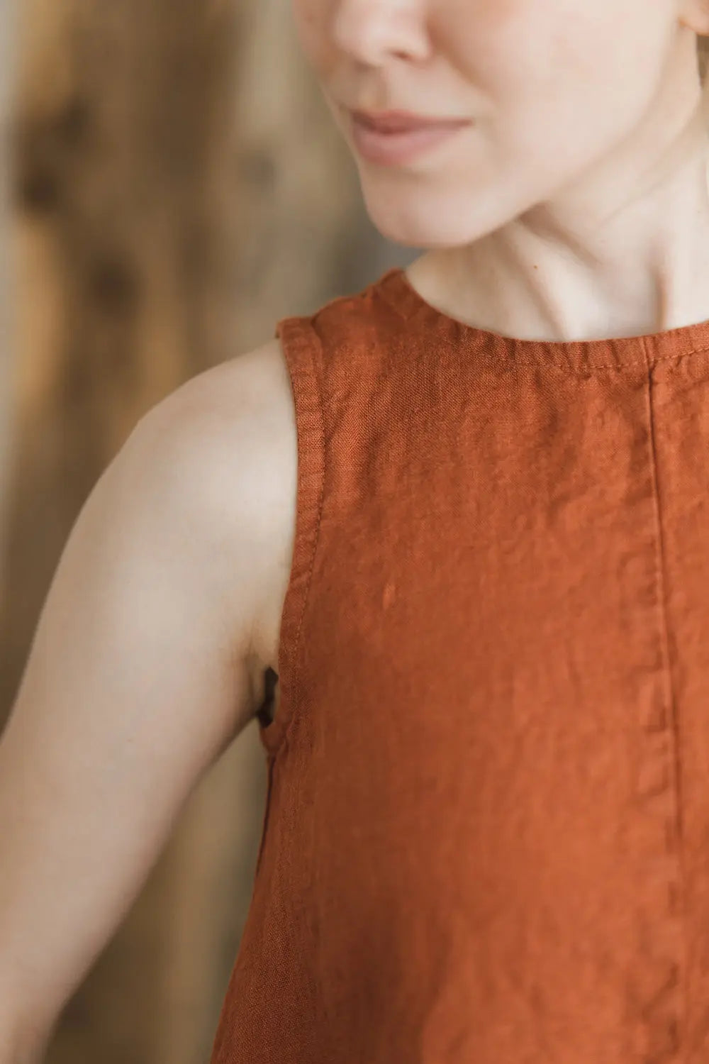 Close-up of round neckline and shoulder detail on a sleeveless natural linen maxi dress